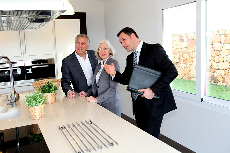 Real-estate agent showing interior of house to senior couple before home inspection services are scheduled