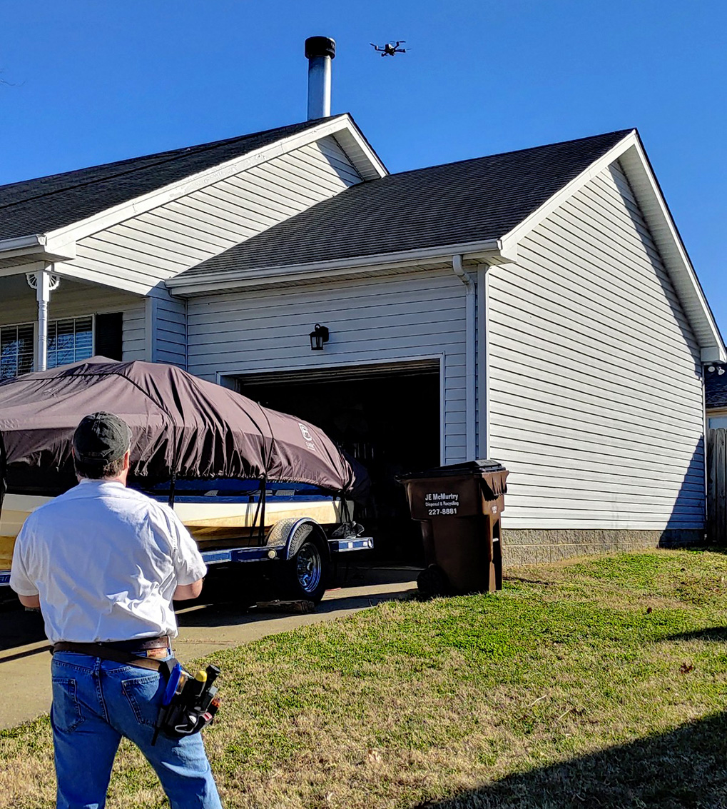 Jim Fuson flying an aerial drone over a house while preforming home inspection services