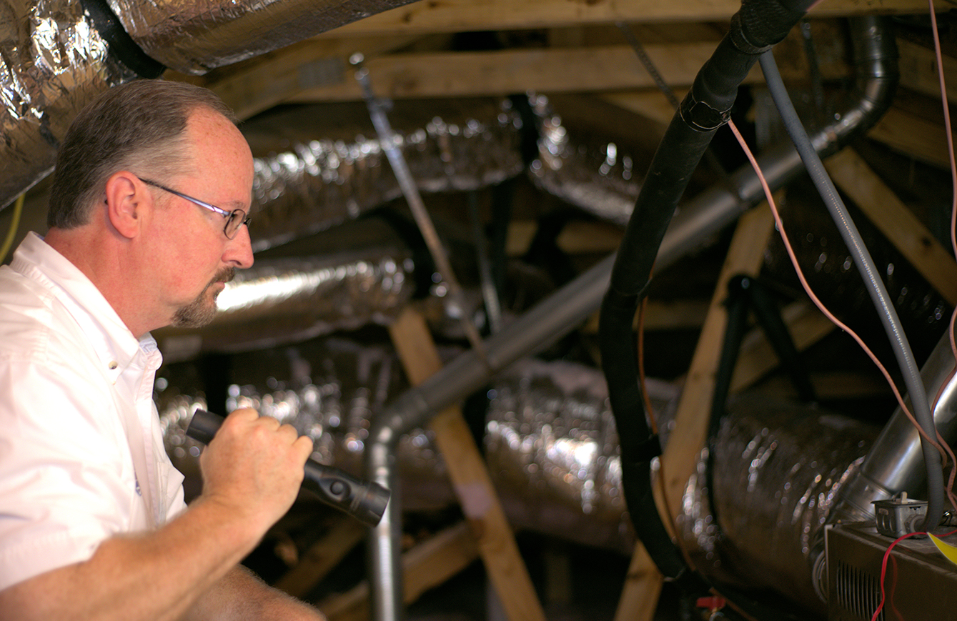 Jim Fuson doing a home inspection in an attic