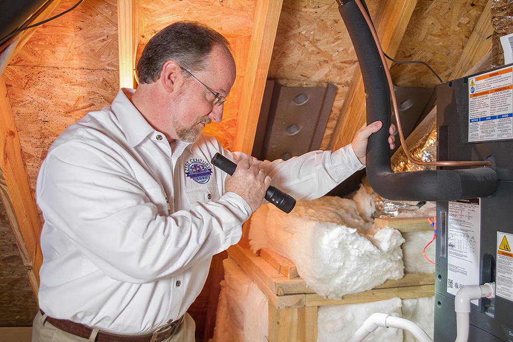 Jim preforming home inspection services in the attic of a house