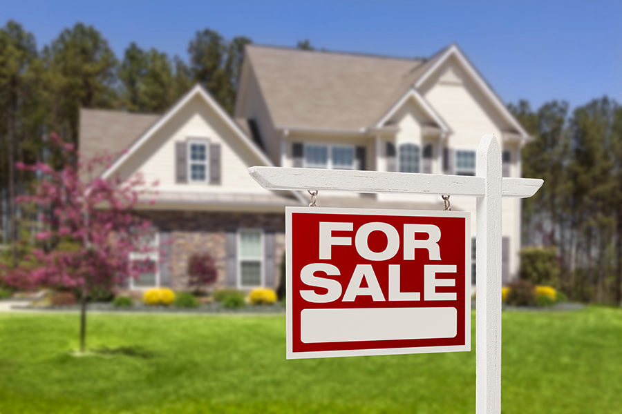 Home For Sale Real Estate Sign in front of a new construction house seen while preforming home inspection services