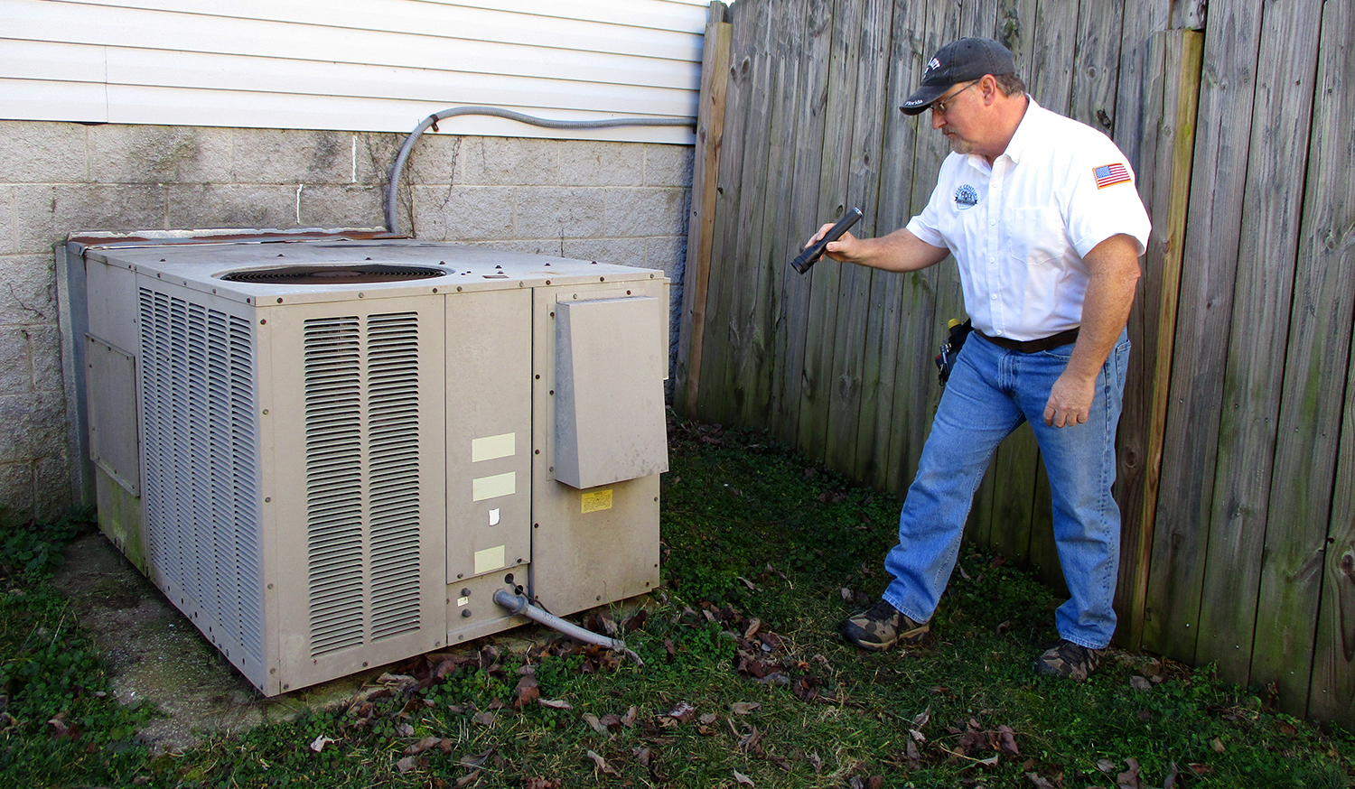 Jim, one of our licensed home inspectors, closely inspecting the exterior of a house