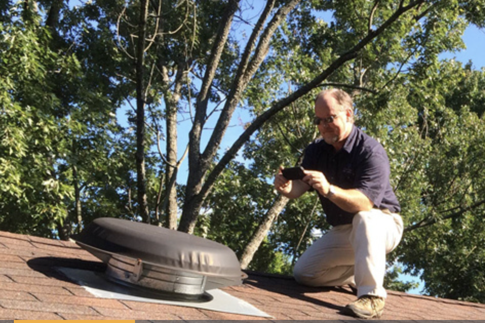 Jim Fuson on the roof of a house preforming home inspection services